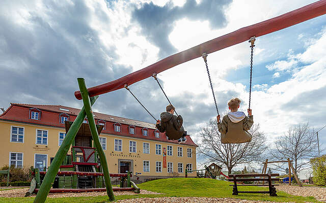 Skatehotel Gutshaus Petkus - schaukelnde Kinder auf Spielplatz