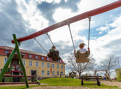 Skatehotel Gutshaus Petkus - schaukelnde Kinder auf Spielplatz