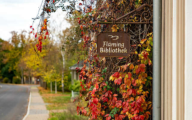 Schild der Fläming-Bibliothek am Gasthof Moritz